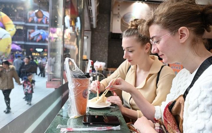 Visitantes estrangeiros experimentam pagamento móvel aprimorado da China durante a Festa da Primavera